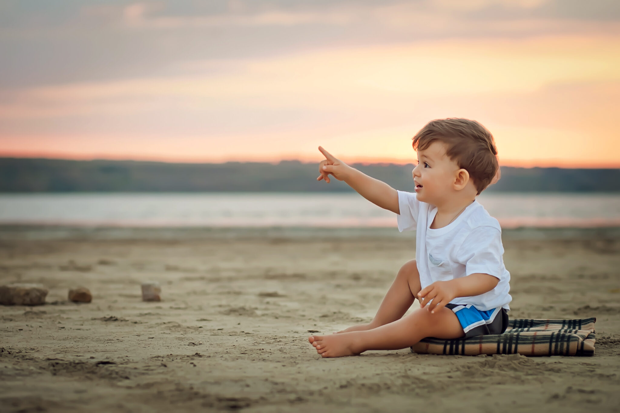 Young child points on beach