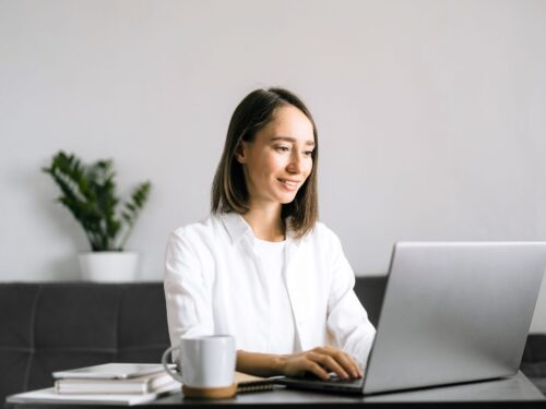 Young woman working on laptop computer in modern office setting